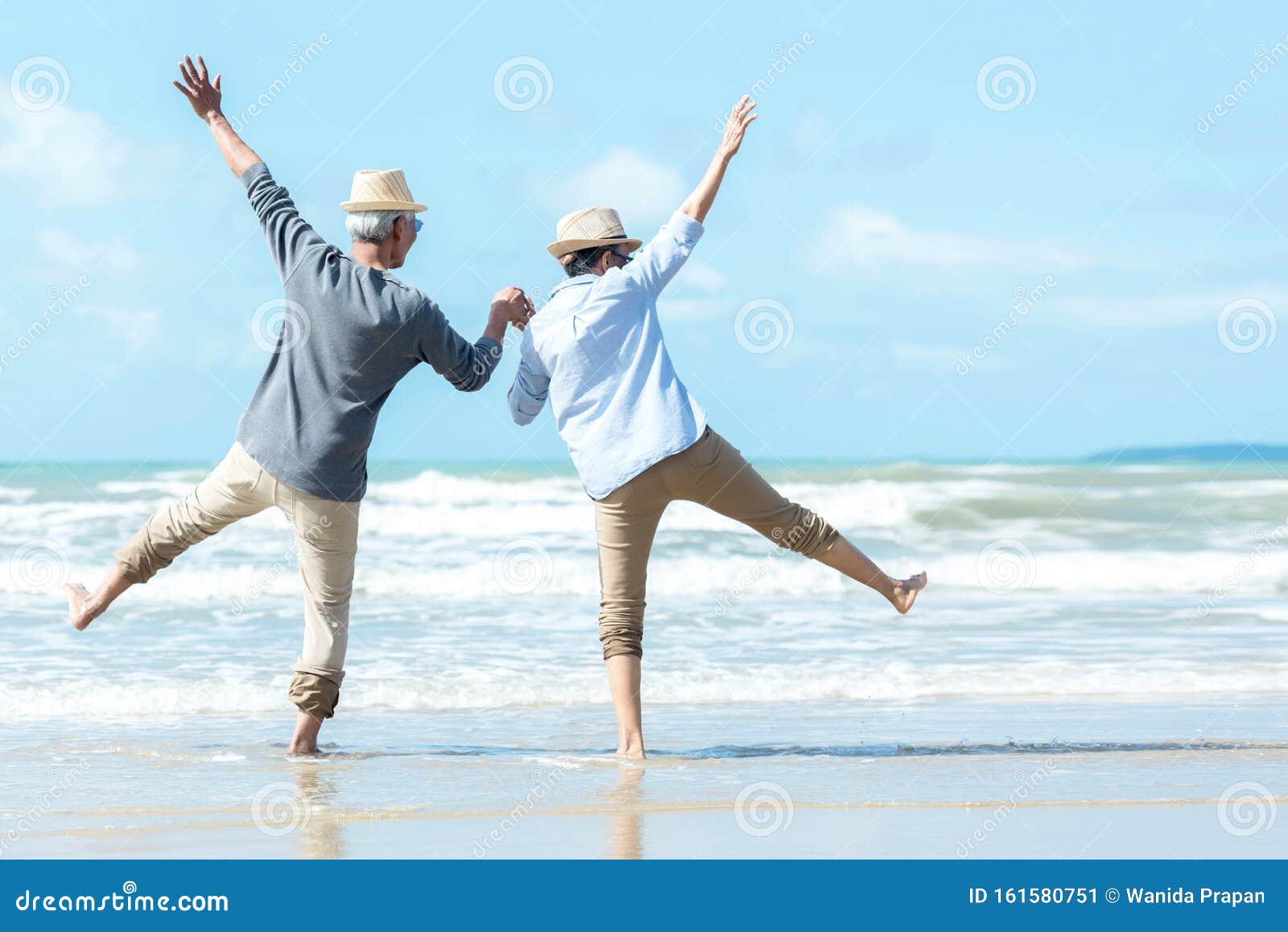 asian lifestyle senior couple jumping on the beach happy in love romantic and relax time.ÃÂ 